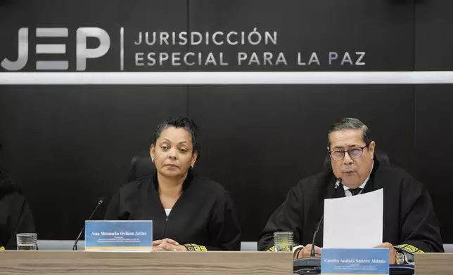 Camilo Andres Suarez, right, and Ana Manuela Ochoa, members of Colombia's peace tribunal, read a guilty sentence for war crimes by former leaders of the Revolutionary Armed Forces of Colombia, FARC, in Bogota, Colombia, Tuesday, Sept. 16, 2025. (AP Photo/Fernando Vergara)