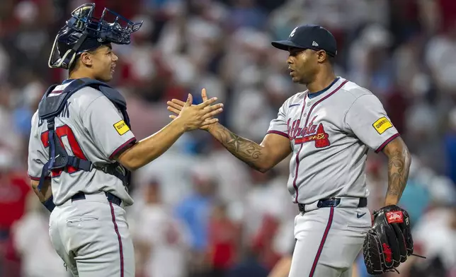 Atlanta Braves relief pitcher Raisel Iglesias, right, celebrates with catcher Drake Baldwin, left, after a baseball game against the Philadelphia Phillies, Sunday, Aug. 31, 2025, in Philadelphia. (AP Photo/Chris Szagola)