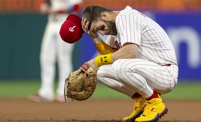 Philadelphia Phillies first baseman Bryce Harper reacts to not being able to catch Atlanta Braves' Michael Harris on a pickoff play during the fifth inning of a baseball game, Sunday, Aug. 31, 2025, in Philadelphia. (AP Photo/Chris Szagola)