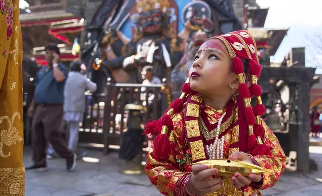 A young Newar girl, dressed to represent divine female energy, waits for Kumari Puja, a ritual during which she would be worshipped, at Hanuman Dhoka, Basantapur Durbar Square, Kathmandu, Nepal, Friday, Sept. 5, 2025. (AP Photo/Niranjan Shrestha)