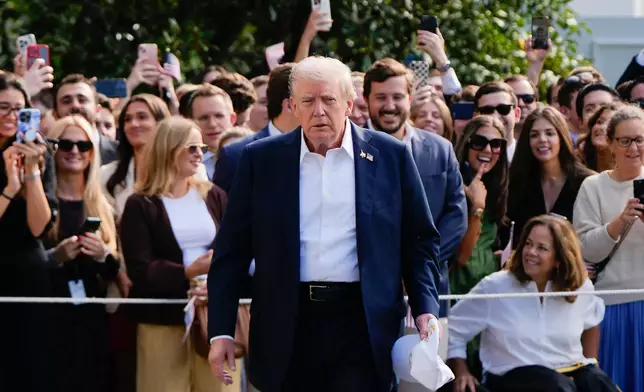 President Donald Trump walks to speak with reporters after greeting supporters before departing the White House, Friday, Sept. 26, 2025, in Washington. (AP Photo/Julia Demaree Nikhinson)