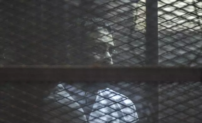 Prominent Egyptian activist Alaa Abd el-Fattah stands in a cage during a verdict hearing for 21 people over an unauthorized street protest in 2013, in a courtroom in Cairo, Egypt, on Feb. 23, 2015. (AP Photo)