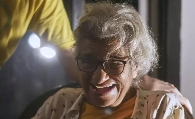 Laila Soueif, the mother of pro-democracy Egyptian-British activist Alaa Abd el-Fattah, who was in prison for almost all of the past 12 years, smiles as she meets her son at home, after a presidential pardon, in Cairo, Egypt, Tuesday, Sept. 23, 2025. (AP Photo/Amr Nabil)