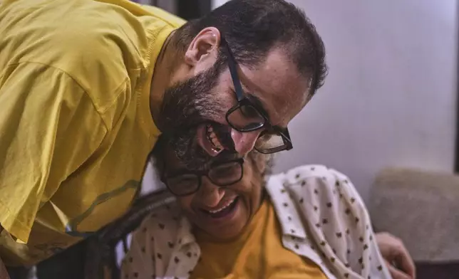 Activist Alaa Abd el-Fattah hugs his mother Laila Soueif, as he arrives at his home, after a presidential pardon, in Cairo, Egypt, Tuesday, Sept. 23, 2025. (AP Photo/Amr Nabil)