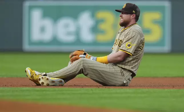 San Diego Padres second base Jake Cronenworth grimaces after a minor injury against the Colorado Rockies during the first inning of a baseball game Friday, Sept. 5, 2025, in Denver. (AP Photo/Jack Dempsey)