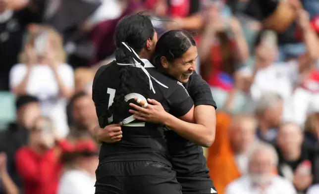 New Zealand's Braxton Sorensen-McGee, right, celebrates with teammate New Zealand's Sylvia Brunt, after she scored a try during the Women's Rugby World Cup bronze match between New Zealand and France at the Allianz Stadium, Twickenham, London, Saturday, Sept. 27, 2025. (AP Photo/Alastair Grant)