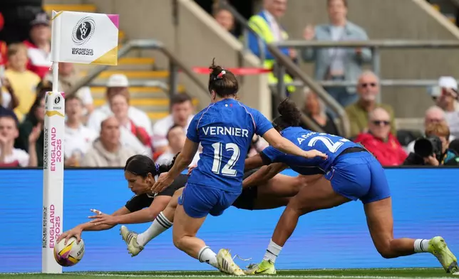 New Zealand's Braxton Sorensen-McGee, left, scores a try past Gaby Vernier of France, center and Kelly Arbey of France, right, during the Women's Rugby World Cup bronze match between New Zealand and France at the Allianz Stadium, Twickenham, London, Saturday, Sept. 27, 2025. (AP Photo/Alastair Grant)