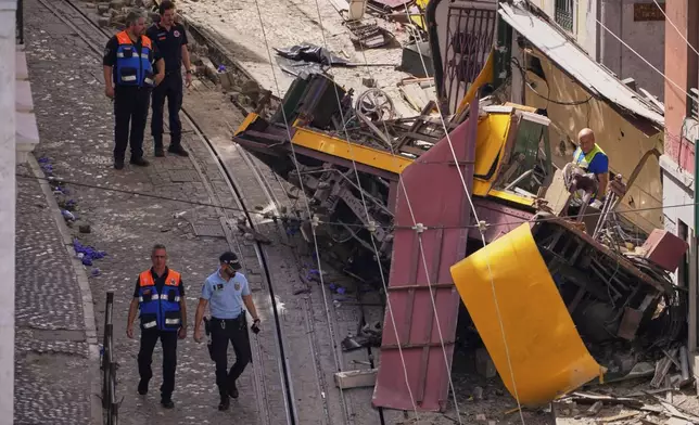 Police officers inspect the site where a tourist streetcar derailed and crashed in Lisbon, Portugal, Thursday, Sept. 4, 2025. (AP Photo/Armando Franca)