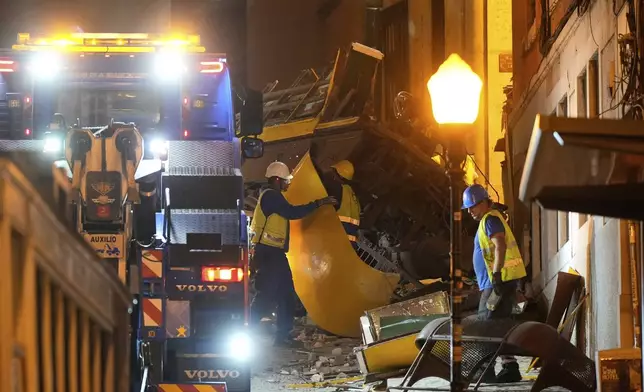 Workers remove the wreckage of a tourist streetcar that derailed and crashed in Lisbon, Thursday, Sept. 4, 2025. (AP Photo/Ana Brigida)