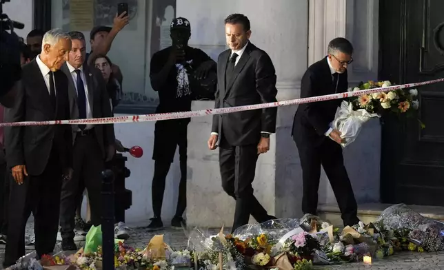 Portuguese President Marcelo Rebelo de Sousa, left, Lisbon Mayor Carlos Moedas, right, and Prime Minister Luis Montenegro visit a makeshift memorial for the victims at the site where a tourist streetcar derailed and crashed in Lisbon, Thursday, Sept. 4, 2025. (AP Photo/Ana Brigida)