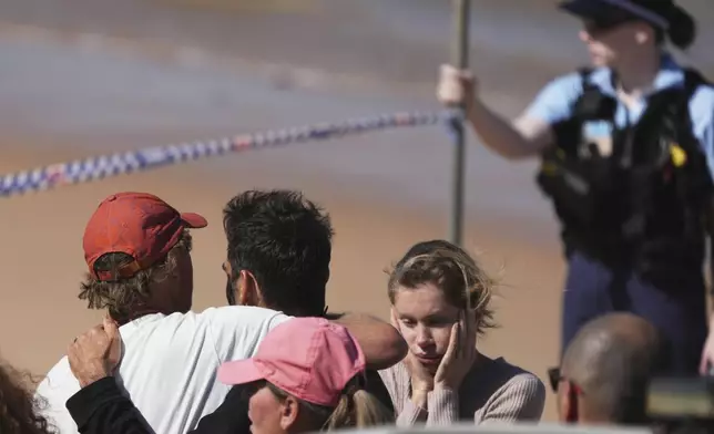 People react at the site of a fatal shark attack at Dee Why Beach in Sydney, Australia, Saturday, Sept. 6, 2025. (AP Photo/Mark Baker)