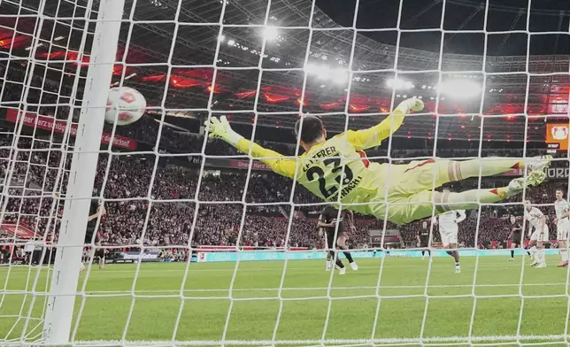 Frankfurt's goalkeeper Michael Zetterer receives the opening goal by Leverkusen's Alex Grimaldo during the German Bundesliga soccer match between Bayer Leverkusen and Eintracht Frankfurt at the BayArena in Leverkusen, Germany, Friday, Sept. 12, 2025. (AP Photo/Martin Meissner)