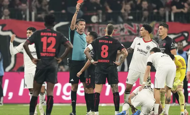 Referee Deniz Aytekin shows the red card to Leverkusen's Robert Andrich during the German Bundesliga soccer match between Bayer Leverkusen and Eintracht Frankfurt at the BayArena in Leverkusen, Germany, Friday, Sept. 12, 2025. (AP Photo/Martin Meissner)