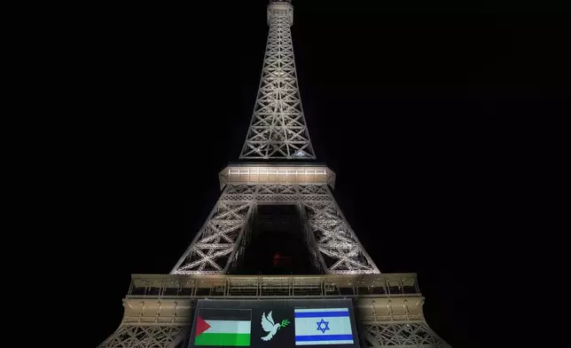 A large screen displays Palestinian and Israeli flags and a dove on the Eiffel Tower, Sunday, Sept. 21, 2025, in Paris, as France prepares to formally recognize a Palestinian state at the United Nations General Assembly. (AP Photo/Christophe Ena)