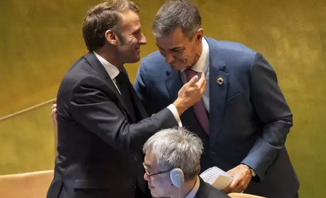 France's President Emmanuel Macron and Spain's Prime Minister Pedro Sanchez embrace each other during a high-profile meeting at the United Nations aimed at galvanizing support for a two-state solution to the Israeli-Palestinian conflict, Monday, Sept. 22, 2025, at U.N. headquarters. (AP Photo/Yuki Iwamura)