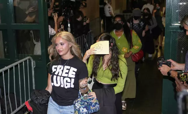 Members of the public, including a woman wearing a "Free Luigi" shirt, enter a courtroom before Luigi Mangione is escorted into the courtroom in New York, Tuesday, Sept. 16, 2025. (AP Photo/Seth Wenig)