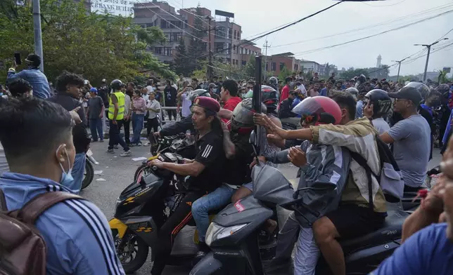 A protester rides on two wheelers carrying a firearm with others during a protest against a social media ban and corruption in Kathmandu, Nepal, Tuesday, Sept. 9, 2025. (AP Photo/Niranjan Shrestha)