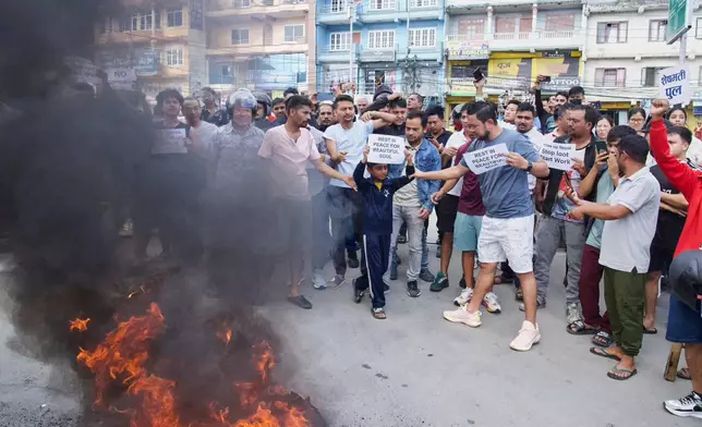 Protesters burn tires violating the curfew orders in Kathmandu, Nepal, Tuesday, Sept. 9, 2025 after Nepal’s government lifted its ban on social media platforms after violent street protests. (AP Photo/Niranjan Shrestha)