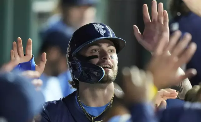 Kansas City Royals' Carter Jensen celebrates in the dugout after scoring on a single by Vinnie Pasquantino during the third inning of a baseball game against the Toronto Blue Jays, Friday, Sept. 19, 2025, in Kansas City, Mo. (AP Photo/Charlie Riedel)
