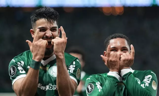 Jose Manuel Lopez of Brazil's Palmeiras, left, celebrates with Vitor Roque of Brazil's Palmeiras, after scoring a penalty goal against Argentina's River Plate during a Copa Libertadores quarterfinal second leg soccer match at Allianz Parque stadium in Sao Paulo, Wednesday, Sept. 24, 2025. (AP Photo/Andre Penner)