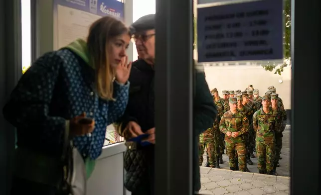 Soldiers wait outside a voting stations to cast their vote during a parliamentary election, in Chisinau, Moldova, Sunday, Sept. 28, 2025. (AP Photo/Vadim Ghirda)