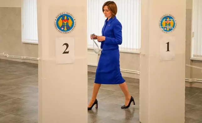Moldova's President Maia Sandu enters a voting booth during a parliamentary election, in Chisinau, Moldova, Sunday, Sept. 28, 2025. (AP Photo/Vadim Ghirda)
