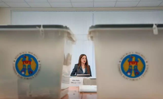 An election official attends to a voting station during a parliamentary election, in Chisinau, Moldova, Sunday, Sept. 28, 2025. (AP Photo/Vadim Ghirda)