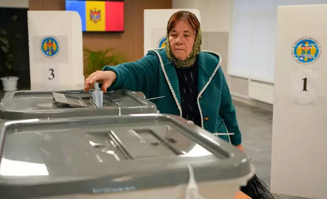 A woman casts her vote during a parliamentary election, in Chisinau, Moldova, Sunday, Sept. 28, 2025. (AP Photo/Vadim Ghirda)