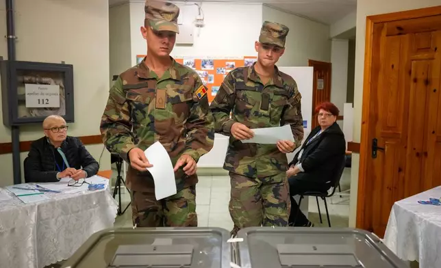 Soldiers prepare to cast their votes during a parliamentary election, in Chisinau, Moldova, Sunday, Sept. 28, 2025. (AP Photo/Vadim Ghirda)