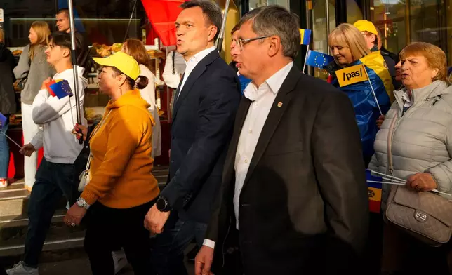 Moldova's Prime Minister Dorin Recean, center left, walks with Igor Grosu, the president of the ruling Party of Action and Solidarity, right, during a pro-EU rally of the ruling Party of Action and Solidarity (PAS), in Chisinau, Moldova, Friday, Sept. 26, 2025, ahead of parliamentary elections taking place on Sept. 28. (AP Photo/Vadim Ghirda)