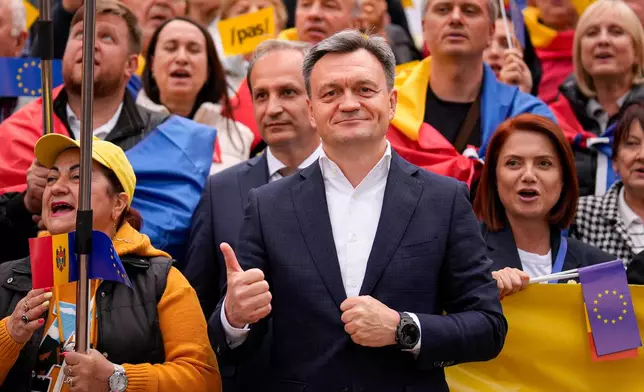 Moldova's Prime Minister Dorin Recean flashes a thumbs up next to supporters during a pro-EU rally of the ruling Party of Action and Solidarity (PAS), in Chisinau, Moldova, Friday, Sept. 26, 2025, ahead of parliamentary elections taking place on Sept. 28. (AP Photo/Vadim Ghirda)