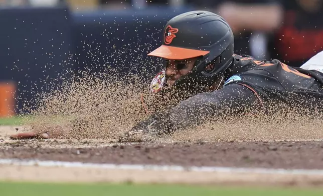 Baltimore Orioles' Jeremiah Jackson slides in to home, scoring off an RBI single by Dylan Beavers during the seventh inning of a baseball game against the San Diego Padres Monday, Sept. 1, 2025, in San Diego. (AP Photo/Gregory Bull)