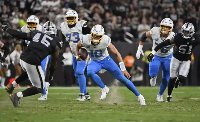 Los Angeles Chargers quarterback Justin Herbert (10) runs with the ball against the Las Vegas Raiders during the first half of an NFL football game, Monday, Sept. 15, 2025, in Las Vegas. (AP Photo/David Becker)