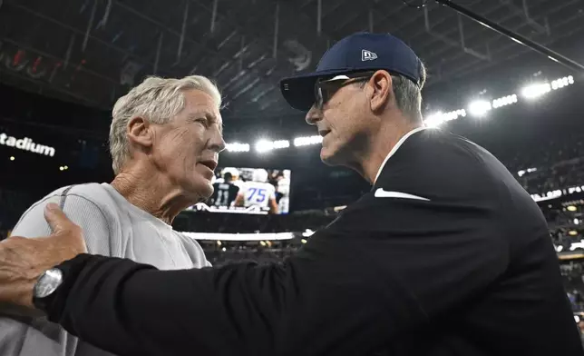 Las Vegas Raiders head coach Pete Carroll, left, and Los Angeles Chargers head coach Jim Harbaugh greet each other following an NFL football game, Monday, Sept. 15, 2025, in Las Vegas. (AP Photo/David Becker)