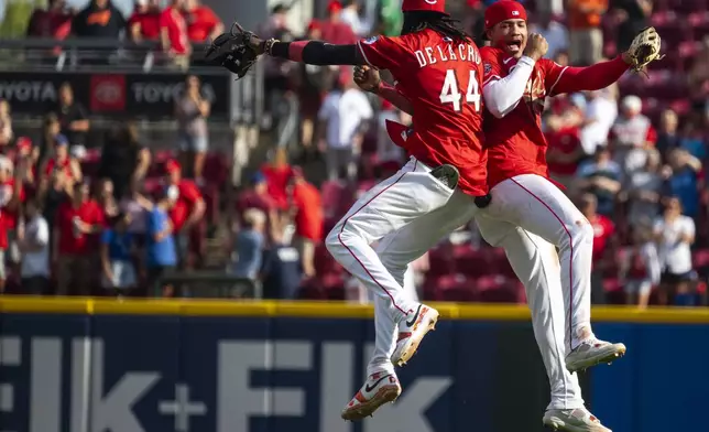 Cincinnati Reds shortstop Elly De La Cruz (44) and outfielder Noelvi Marte (16) bump shoulders after defeating the Chicago Cubs, Sunday, Sept. 21, 2025, in Cincinnati. (AP Photo/Michael Swensen)