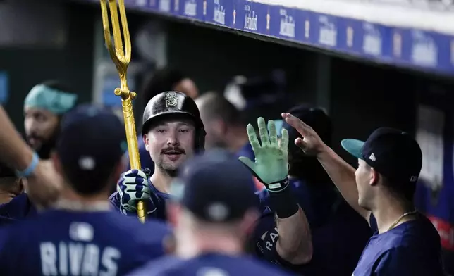 Seattle Mariners' Cal Raleigh carries a trident after hitting a solo home run, his 57th of the season, against the Houston Astros during the third inning of a baseball game Saturday, Sept. 20, 2025, in Houston. (AP Photo/Eric Christian Smith)
