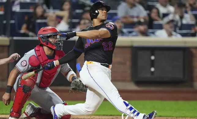 Washington Nationals catcher Jorge Alfaro, left, watches as New York Mets' Juan Soto hits a three-run home run during the fourth inning of a baseball game Friday, Sept. 19, 2025, in New York. (AP Photo/Frank Franklin II)