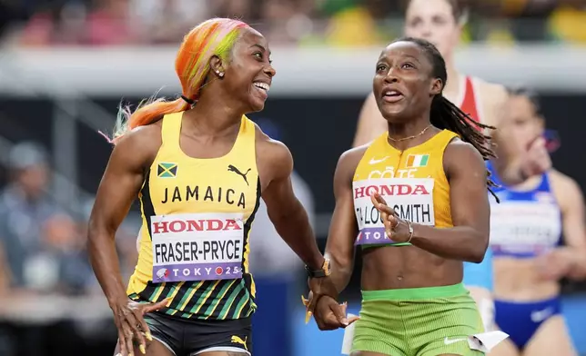 Jamaica's Shelly-Ann Fraser-Pryce, left, and The Ivory Coast's Marie-Josee Ta Lou-Smith react after crossing the finish line in the women's 100 meters heat at the World Athletics Championships in Tokyo, Saturday, Sept. 13, 2025. (AP Photo/Eugene Hoshiko)