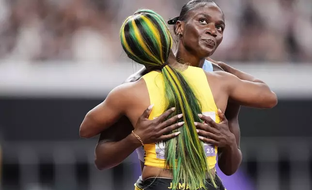 Jamaica's Shelly-Ann Fraser-Pryce embraces Saint Lucia's Julien Alfred after crossing the finish line while competing in the women's 100 meters semi-final at the World Athletics Championships in Tokyo, Sunday, Sept. 14, 2025. (AP Photo/Eugene Hoshiko)