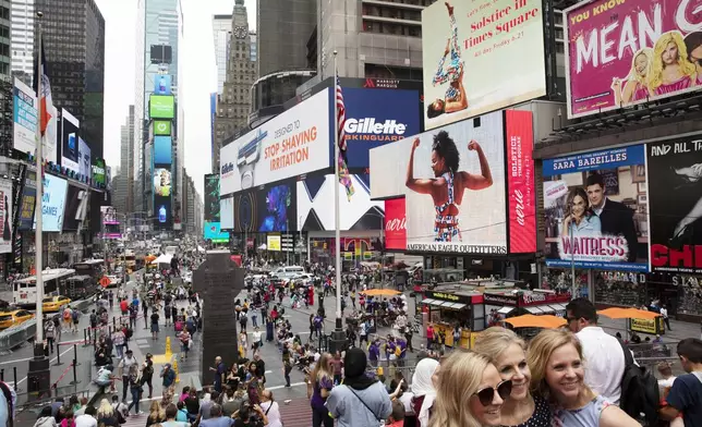 FILE - In this June 20, 2019, file photo, tourists visit Times Square in New York. (AP Photo/Mark Lennihan, File)