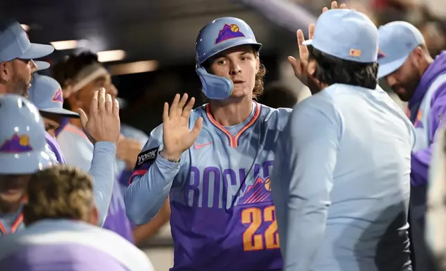 Colorado Rockies' Mickey Moniak (22) celebrates in the dugout after scoring in the fifth inning of a baseball game against the Los Angeles Angels Friday, Sept. 19, 2025, in Denver. (AP Photo/Geneva Heffernan)