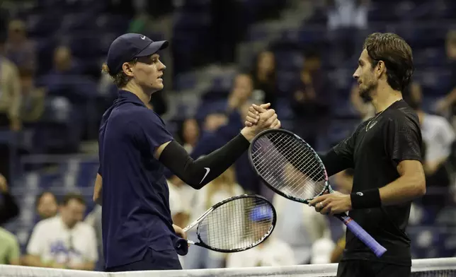 Jannik Sinner, left, of Italy, shakes hands with Lorenzo Musetti, of Italy, after defeating him during the quarterfinal round of the U.S. Open tennis championships, Wednesday, Sept. 3, 2025, in New York. (AP Photo/Adam Hunger)