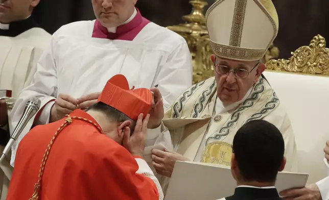 FILE - Cardinal Giovanni Angelo Becciu receives the red three-cornered biretta hat from Pope Francis during a consistory in St. Peter's Basilica at the Vatican, June 28, 2018. (AP Photo/Alessandra Tarantino, File)