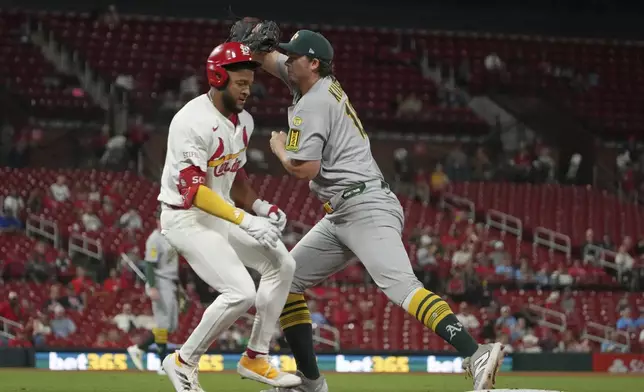 St. Louis Cardinals' Victor Scott II, left, grounds out as Athletics first baseman Nick Kurtz handles the throw during the eighth inning of a baseball game Tuesday, Sept. 2, 2025, in St. Louis. (AP Photo/Jeff Roberson)