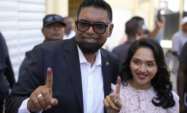President Irfaan Ali, seeking another term, and his wife Arya Ali show their inked fingers after voting during general elections in Leonora, Guyana, Monday, Sept. 1, 2025. (AP Photo/Matias Delacroix)