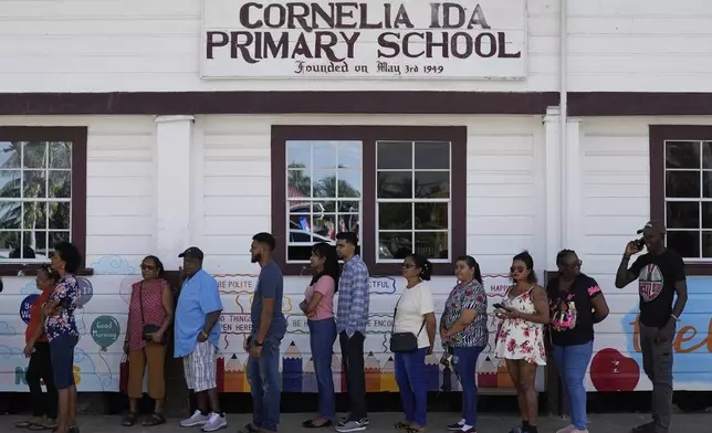 Voters line up at a polling station during general elections in Cornelia Ida, Guyana, Monday, Sept. 1, 2025. (AP Photo/Matias Delacroix)