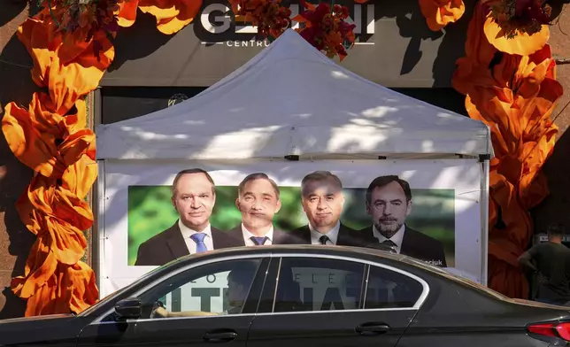 A man sits in a car in front of a campaign tent of the Alternative Electoral Bloc in Chisinau, Moldova, Tuesday, Sept. 23, 2025, ahead of parliamentary elections taking place on Sept. 28. (AP Photo/Vadim Ghirda)