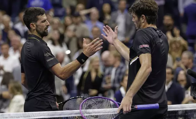 Novak Djokovic, of Serbia, shakes hands with Taylor Fritz, of the United States, after winning the match during the quarterfinal round of the U.S. Open tennis championships, Tuesday, Sept. 2, 2025, in New York. (AP Photo/Adam Hunger)