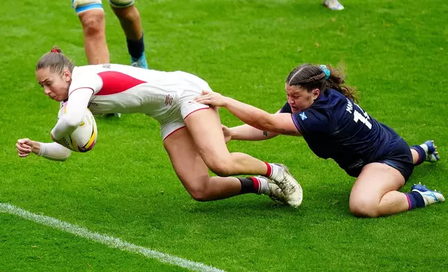 England's Holly Aitchison, left, scores during the Women's Rugby World Cup 2025 quarter-final match between England and Scotland in Bristol, England, Sunday Sept. 14, 2025. (Andrew Matthews/PA via AP)