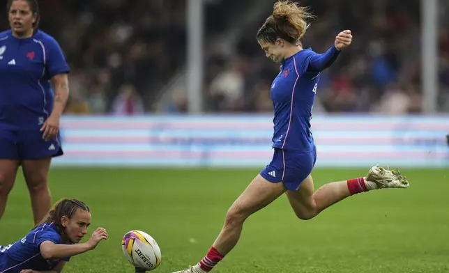 France's Morgane Bourgeois, right, kicks a penalty during a Women's Rugby World Cup 2025 quarterfinal match between France and Ireland, in Exeter, England, Sunday, Sept. 14, 2025. (AP Photo/Alastair Grant)